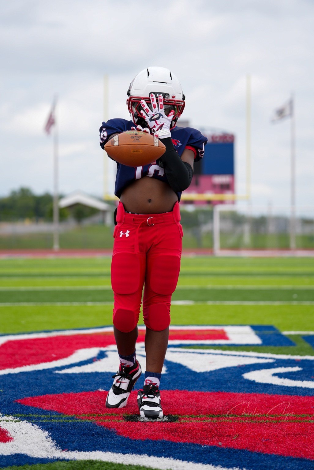 Football player holding ball and glove pose